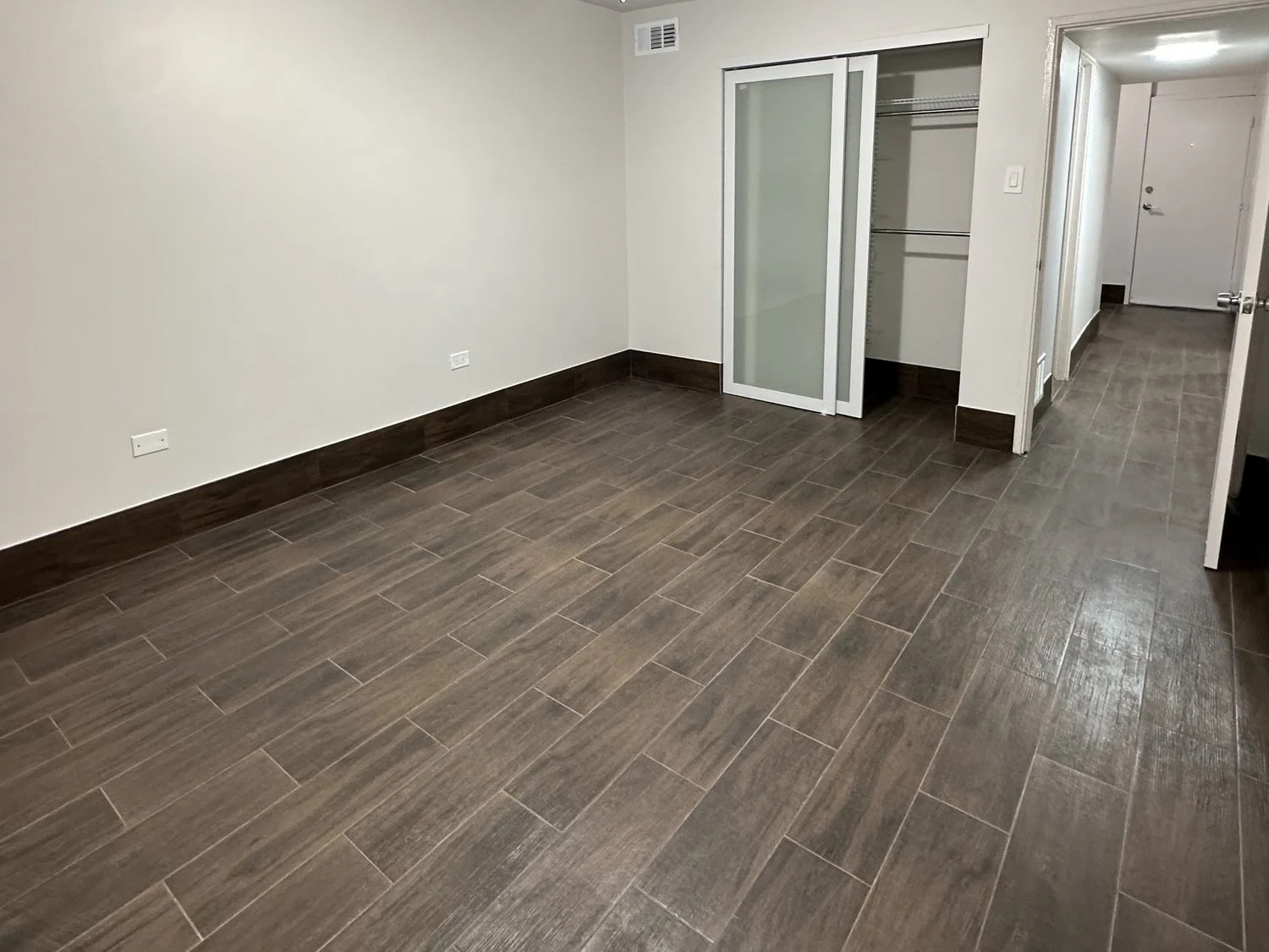 Room with wood-look flooring and closet storage in a Crescendo apartment