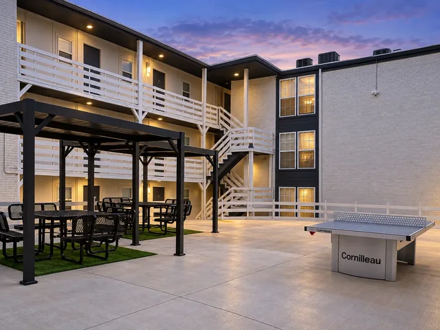 Twilight view of the Crescendo courtyard with covered picnic seating and a table-tennis table